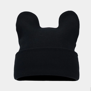 Close-up of the knitted texture and cute animal ears on the black winter beanie hat