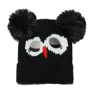 Detailed knit texture of a black cartoon owl beanie with fluffy pom-poms and embroidery