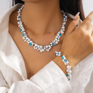 Elegant pearl and rhinestone jewelry set with blue accents on a fashion model