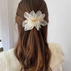 Barrette fleur en organza blanc sur cheveux longs pour un style estival romantique