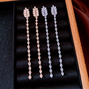 Détail de boucles d'oreilles pompons plaquées or 18 carats avec cristaux de zircon