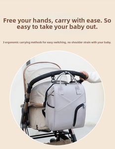 Waterproof baby diaper bag hanging on a stroller with durable hooks for easy travel
