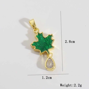 Détail du pendentif feuille en émail vert avec cristal goutte d'eau plaqué or 18 carats