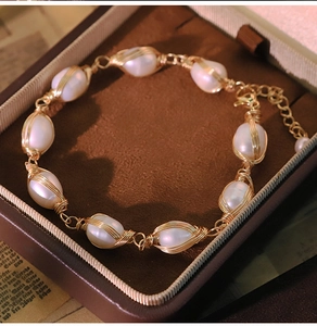 Detail of freshwater pearl bracelet with gold wire wrapping and lobster clasp in box