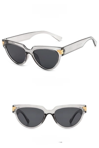 Dettaglio degli occhiali da sole cat-eye grigio trasparente con finiture in metallo oro