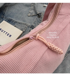 Detail of smooth pink zipper and woven puller on high-quality corduroy dumpling bag