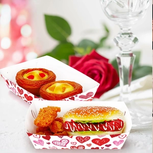 Close-up of Valentine's Day snack trays with heart patterns filled with party food