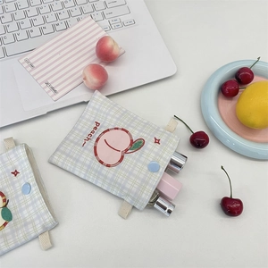 Detailed view of blue checkered peach pouch with embroidery for lipstick and jewelry storage
