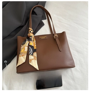 Detail einer braunen Leder-Shopper mit dekorativem Seidentuch und goldenen Schnallen