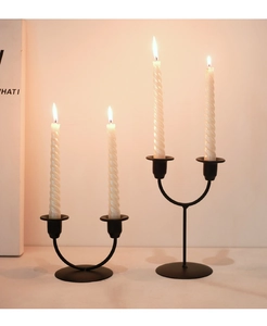Detail of minimalist black metal double-head U-shaped candle holders with spiral candles