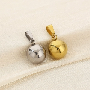 Close-up of polished gold and silver spherical stainless steel pendants on silk