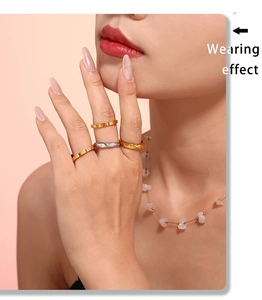 Effet de porter des bagues dorées avec diamants et collier avec pierre rose sur modèle