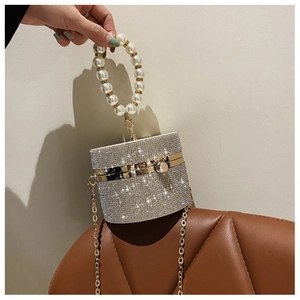 Detailed macro view of sparkling rhinestone cylinder bag with a faux pearl beaded handle
