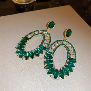Detail of emerald green crystal geometric earrings with ornate marquise rhinestones