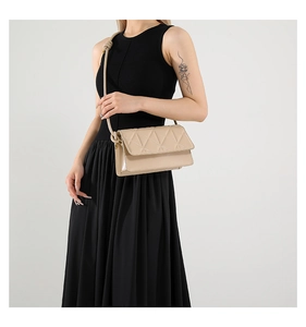 Detail of beige quilted PU leather square bag with knot-style shoulder strap decoration