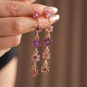 Elegant gold-tone tassel earrings featuring colorful floral rhinestones in a long drop style