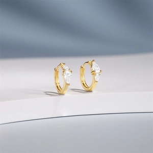 Macro detail of gold-plated S925 silver hoop earrings with pear-cut cubic zirconia