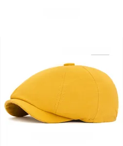 Detailed close-up of yellow octagonal newsboy cap showing twill cotton fabric and stitching