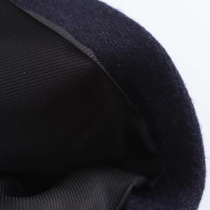Macro view of navy wool blend coat detail featuring fine fiber texture and reinforced black lining