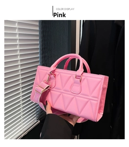 Detail of pink quilted handbag showing triangle stitching and wide adjustable strap