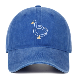 Detail of silly goose white embroidery on washed navy blue cotton baseball cap