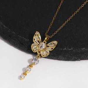 Détail du collier papillon doré avec glands en zircone sur une pierre noire