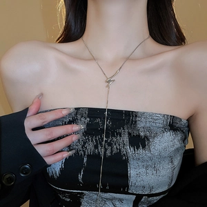 Detail of silver twisted knot Y-shaped necklace worn on neck for a minimalist style