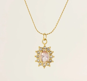 Macro shot of sunflower pendant with pink zircon center and white diamonds on gold chain