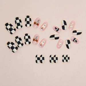 Halloween checkered press-on nails with ghost, pumpkin cherry, and moon patterns