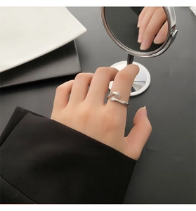 Detail van zilveren ring met knuffelende handen op vinger met elegante gepolijste afwerking