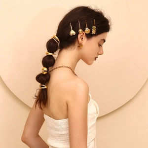 Detail view of 18K gold plated scallop hair clip with zircons worn on model's hair