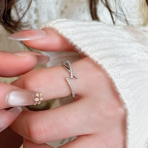 Detail of adjustable silver bow ring featuring sparkling zircon stones on a model hand