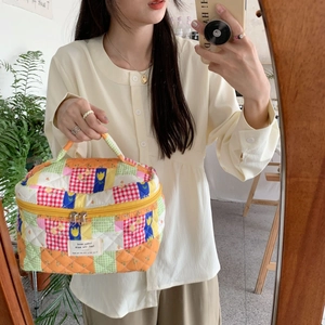 Patchwork floral cotton makeup bag held by a model in a cozy home mirror selfie