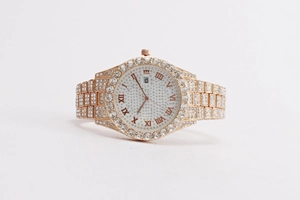 Detail of gold crystal watch featuring roman numerals dial and date window display