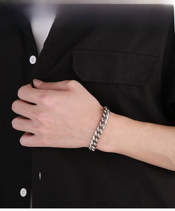 Macro shot of silver Cuban link bracelet on wrist highlighting metallic shine and texture