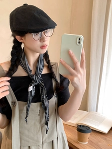 Close-up of a vintage striped fabric neck scarf worn by a model in a cozy lifestyle setting