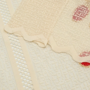 Close-up of beige lace tablecloth with scalloped edges and intricate embroidery details