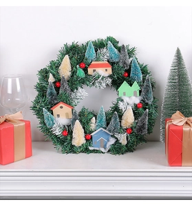 Close-up of Christmas wreath with miniature houses and berries on a white fireplace