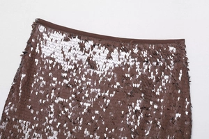 Détails de sequins marron foncé scintillants sur une mini-jupe à reflets métalliques