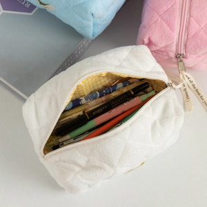 Detailed view of quilted makeup bag with checkered lining and large storage capacity