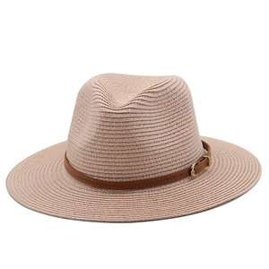 Close-up of woven straw sun hat texture with brown leather band and gold metal buckle