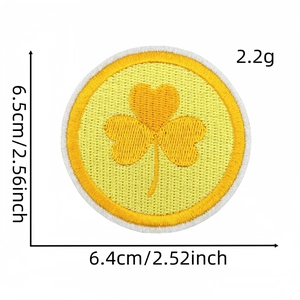 Detailed view of yellow shamrock embroidered patch showing 6.5cm dimensions and size scale