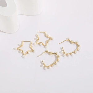 Minimalist gold plated heart and star earrings with white pearl beads on a white background