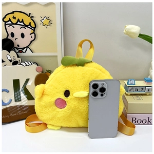 Close-up of cute yellow plush chicken backpack showing size comparison with a phone
