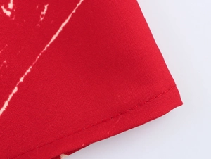 Détail du tissu rouge de la robe de vacances avec imprimé cocotier et coutures