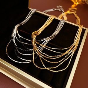 Detail of layered gold and silver snake chain necklaces in a premium jewelry display box