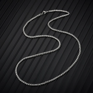 Macro shot of silver stainless steel woven chain on a textured black background