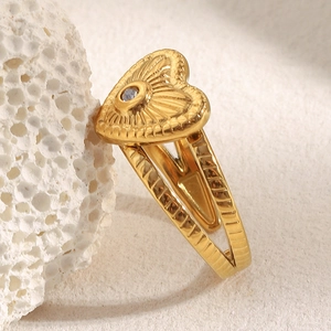 Détail d'une bague cœur plaquée or 18 carats avec cristal bleu sur corail blanc