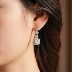 Elegant silver earrings with square zircon pendant worn by model for luxury styling