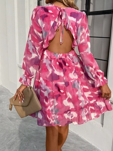 Back view of elegant V-neck mini dress featuring pink purple tie-dye print and tie-back detail